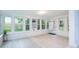 Bright sunroom with large windows, wood-look flooring, and built-in shelving at 5625 Atlantic N Ave, St Petersburg, FL 33703