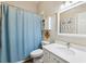 Bathroom with speckled vanity, large mirror, and a shower tub with blue shower curtain at 5823 Terncrest Dr, Lithia, FL 33547
