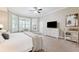 Bright bedroom featuring neutral walls, a ceiling fan, a dresser with a TV, and plantation shutters on the windows at 5823 Terncrest Dr, Lithia, FL 33547