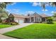 Inviting single-story home with lush front yard and well-maintained lawn with driveway and ample garage space at 5823 Terncrest Dr, Lithia, FL 33547