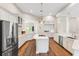 Bright, open kitchen with white cabinets, granite countertops, stainless steel appliances, and a large island with gas cooktop at 5823 Terncrest Dr, Lithia, FL 33547