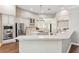 Bright, open kitchen with white cabinets, granite countertops, stainless steel appliances, and a large island with gas cooktop at 5823 Terncrest Dr, Lithia, FL 33547