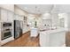 Bright, open kitchen with white cabinets, granite countertops, stainless steel appliances, and a large island with gas cooktop at 5823 Terncrest Dr, Lithia, FL 33547