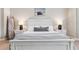 Close-up of the primary bedroom's luxurious white furniture, soft lighting, and nautical-themed artwork at 5823 Terncrest Dr, Lithia, FL 33547