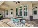 Covered outdoor patio with tiled flooring, outdoor dining set, and multiple access doors and windows at 5823 Terncrest Dr, Lithia, FL 33547
