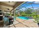 Spacious screened-in patio with outdoor seating and dining areas overlooking a pool and landscaped yard at 5823 Terncrest Dr, Lithia, FL 33547