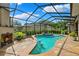 Beautiful screened-in pool with spa, tiled patio, outdoor fireplace, and lush landscaping at 5823 Terncrest Dr, Lithia, FL 33547