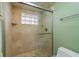 Bathroom shower featuring glass door, tile surround and glass block window at 6340 Garland Ct, New Port Richey, FL 34652