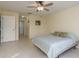 Bright bedroom featuring tile flooring, ceiling fan, and a door leading to the hallway at 6340 Garland Ct, New Port Richey, FL 34652