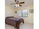 Cozy bedroom with tile floors, bright windows, and a ceiling fan with decorative light fixture at 6340 Garland Ct, New Port Richey, FL 34652