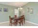 Charming dining room with wooden table, chair set, pendant lighting, neutral color walls, and vertical blinds at 6340 Garland Ct, New Port Richey, FL 34652