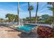 Community hot tub area featuring palm trees, comfortable lounge chairs, and water views at 6340 Garland Ct, New Port Richey, FL 34652