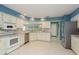 Kitchen features white cabinetry, stainless steel appliances, tile backsplash, bar seating, and stainless refrigerator at 6340 Garland Ct, New Port Richey, FL 34652