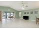 Spacious living room with tile flooring, fan, and sliding doors to outdoor area at 6340 Garland Ct, New Port Richey, FL 34652