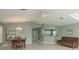 Open-concept living area featuring tile floors, ceiling fan, dining area, and bar-style seating to the kitchen at 6340 Garland Ct, New Port Richey, FL 34652