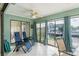 Bright sunroom with tile floors, ceiling fan, waterfront views, and comfortable lounge chairs at 6340 Garland Ct, New Port Richey, FL 34652