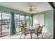 Charming sunroom featuring tile floors, ceiling fan, and beautiful waterfront views, perfect for relaxation and entertaining at 6340 Garland Ct, New Port Richey, FL 34652