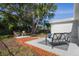 Inviting backyard featuring patio with seating, a mature tree and shade at 6442 Sutherland Ave, New Port Richey, FL 34653