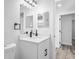 Well-lit bathroom featuring a modern vanity, a large mirror, and updated fixtures at 6442 Sutherland Ave, New Port Richey, FL 34653