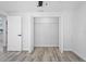 Bedroom featuring closet with double doors, a ceiling fan and sleek, gray, wood-look flooring at 6442 Sutherland Ave, New Port Richey, FL 34653