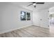 Bright bedroom with wood floors, a ceiling fan, and a large window for natural light at 6442 Sutherland Ave, New Port Richey, FL 34653