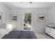 Cozy bedroom with modern decor, a comfortable bed, and a sliding glass door to the outdoor patio at 6442 Sutherland Ave, New Port Richey, FL 34653
