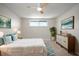 Stylishly decorated bedroom with a queen bed, dresser, modern art and ceiling fan at 6841 Mitchell Cir, Tampa, FL 33634