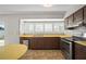 Traditional-style kitchen featuring dark wood cabinets, stainless steel appliances, and a window with bright, natural light at 6841 Mitchell Cir, Tampa, FL 33634
