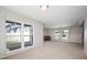 Spacious living room featuring neutral carpeting, bright windows, and access to the exterior and upstairs at 6841 Mitchell Cir, Tampa, FL 33634