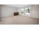 Carpeted living room featuring large windows with backyard views, and a piano at 6841 Mitchell Cir, Tampa, FL 33634