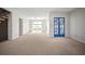Spacious living room with neutral carpet, bright windows, and striking blue glass paneled doors at 6841 Mitchell Cir, Tampa, FL 33634