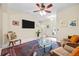 Open-concept living room with a ceiling fan, stylish decor, and access to the entryway at 6934 Duffy Ln, Tampa, FL 33616