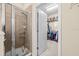 Modern tile shower with a glass door and open access to a walk-in closet for added convenience at 6934 Duffy Ln, Tampa, FL 33616