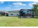 Well-manicured backyard featuring a screened-in lanai with nice landscaping at 7116 Estero Ct, Apollo Beach, FL 33572