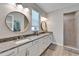 Bathroom features double sinks, granite countertops, decorative mirrors, and a walk-in shower with tiled walls at 7116 Estero Ct, Apollo Beach, FL 33572