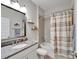 Bathroom featuring granite counters, chrome hardware, a shower-tub combo, and decorative shelves at 7116 Estero Ct, Apollo Beach, FL 33572