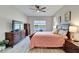 Comfortable bedroom features a ceiling fan, wood-look floors, and a beautiful water view from the window at 7116 Estero Ct, Apollo Beach, FL 33572