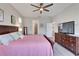 Comfortable bedroom features a ceiling fan, wood-look floors, and easy access to the ensuite bathroom and laundry at 7116 Estero Ct, Apollo Beach, FL 33572