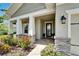 Welcoming front porch with stone accents, decorative plants, and stylish outdoor lighting at 7116 Estero Ct, Apollo Beach, FL 33572