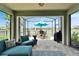Screened lanai featuring a comfortable seating area and dining set, overlooking a serene lake at 7116 Estero Ct, Apollo Beach, FL 33572