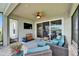 Cozy outdoor living space with comfortable seating, a ceiling fan, and a view of the lush backyard at 7116 Estero Ct, Apollo Beach, FL 33572