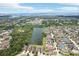Scenic aerial view of homes nestled around a serene lake, showcasing a tranquil neighborhood setting at 7509 Tangle Bend Dr, Gibsonton, FL 33534