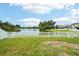 Backyard view with white fence and a lake behind at 7509 Tangle Bend Dr, Gibsonton, FL 33534