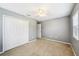 Carpeted bedroom with a ceiling fan, a closet, and a window overlooking a landscaped yard at 7509 Tangle Bend Dr, Gibsonton, FL 33534
