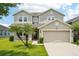 Charming two-story home featuring a well-manicured lawn and a two-car garage at 7509 Tangle Bend Dr, Gibsonton, FL 33534