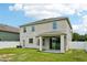Back exterior view with covered patio and green lawn at 7509 Tangle Bend Dr, Gibsonton, FL 33534
