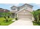Charming home exterior featuring a well-manicured lawn, beautiful landscaping, and a spacious two-car garage at 7509 Tangle Bend Dr, Gibsonton, FL 33534