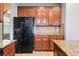 Kitchen with stainless steel refrigerator and wood cabinets with granite countertops at 7509 Tangle Bend Dr, Gibsonton, FL 33534