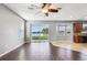 Bright living room with wood flooring, large windows, and sliding door to backyard at 7509 Tangle Bend Dr, Gibsonton, FL 33534
