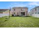 Back exterior view of home featuring a large backyard with a white fence and screened in porch at 7641 Armonk Ln, Wesley Chapel, FL 33545